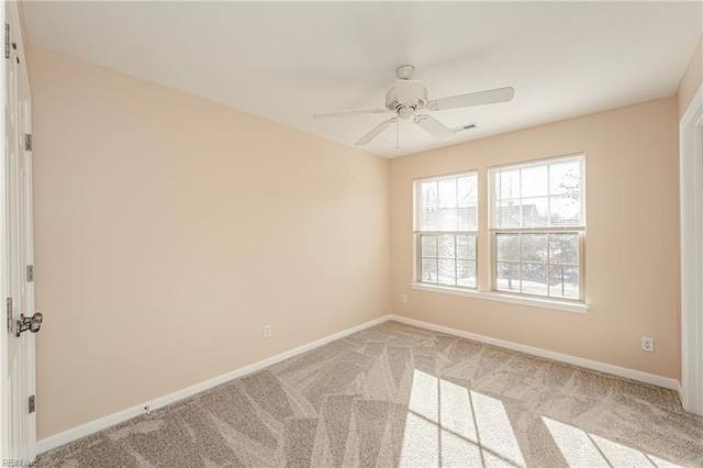 carpeted spare room featuring ceiling fan