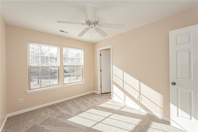 empty room with ceiling fan and light colored carpet