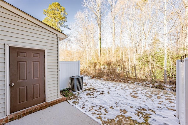 snowy yard featuring central AC