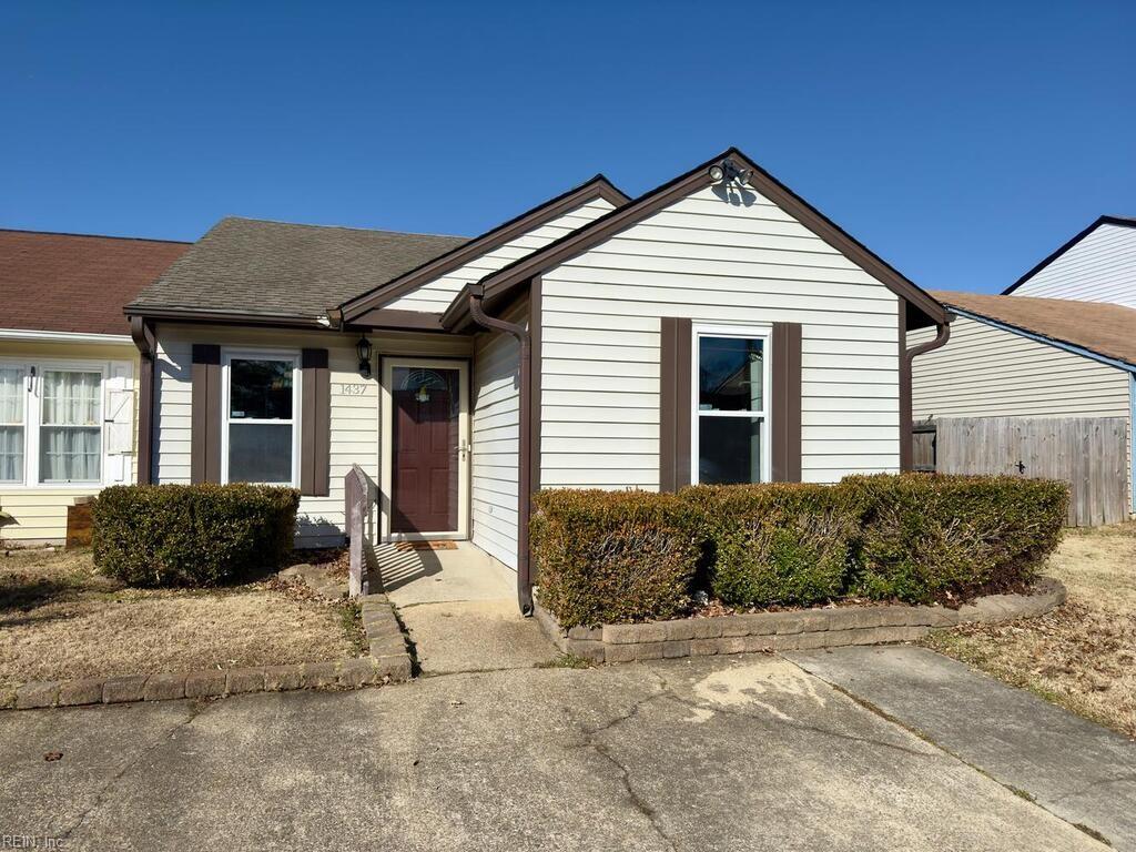 view of front facade featuring a shingled roof and fence