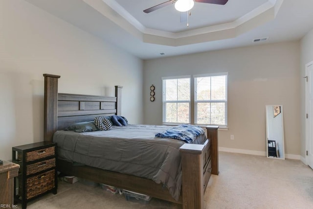 carpeted bedroom with a tray ceiling and ceiling fan