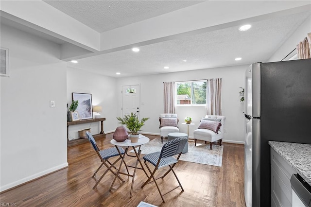 dining area featuring dark hardwood / wood-style floors and a textured ceiling