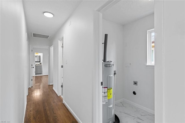 corridor with hardwood / wood-style floors and a textured ceiling