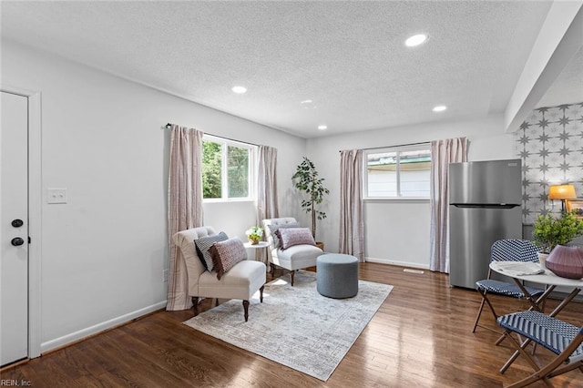 living area with dark hardwood / wood-style flooring and a textured ceiling