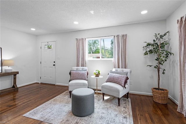 sitting room with dark hardwood / wood-style flooring and a textured ceiling