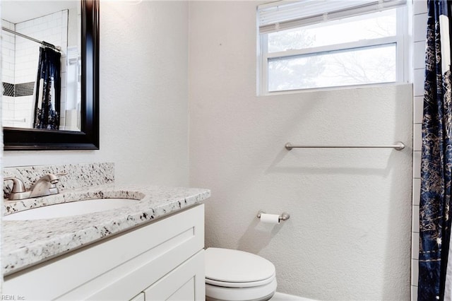 bathroom featuring toilet, a shower with curtain, and vanity