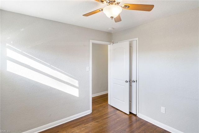 unfurnished room with ceiling fan and dark hardwood / wood-style flooring