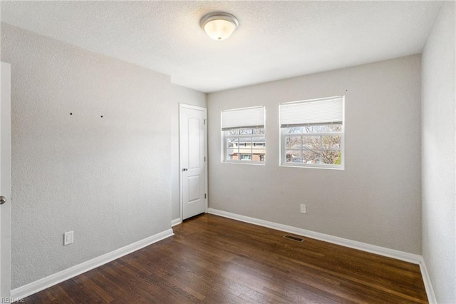 spare room featuring dark hardwood / wood-style floors