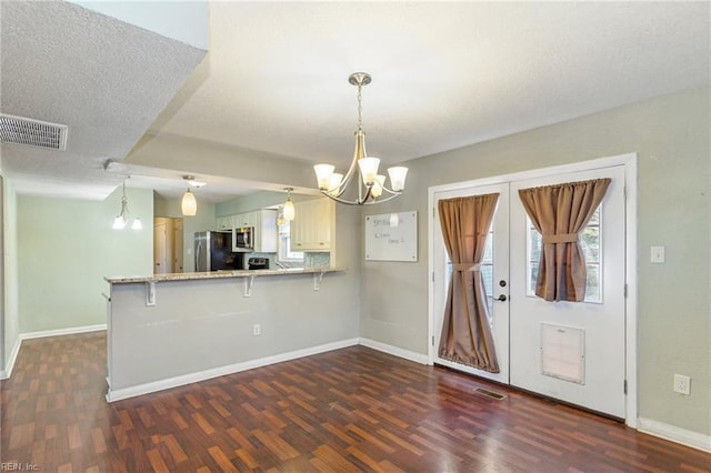 kitchen featuring a breakfast bar, kitchen peninsula, stainless steel appliances, and pendant lighting