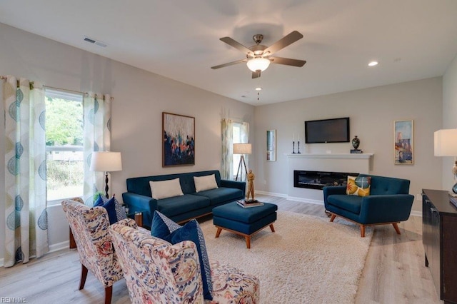 living room featuring ceiling fan and light wood-type flooring