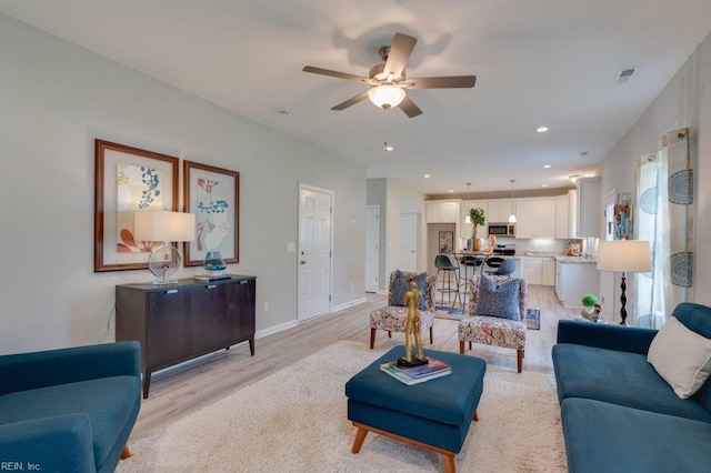 living room featuring ceiling fan and light hardwood / wood-style flooring