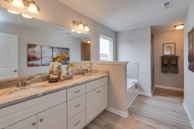 bathroom with shower with separate bathtub, vanity, and hardwood / wood-style flooring