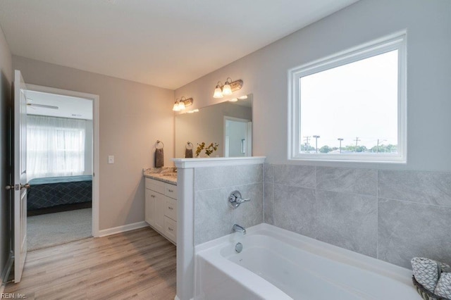 bathroom featuring wood-type flooring, vanity, and a bathtub