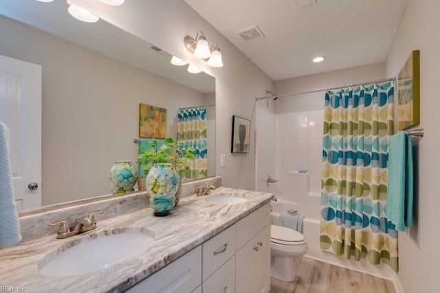 full bathroom featuring toilet, wood-type flooring, vanity, and shower / bath combo