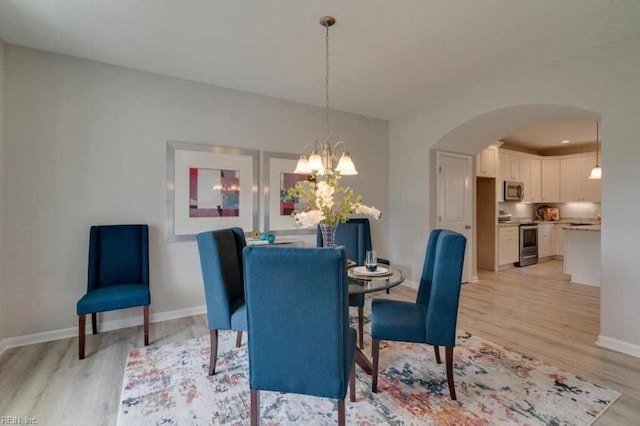 dining space with a notable chandelier and light hardwood / wood-style floors