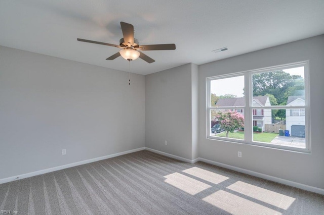 carpeted spare room featuring ceiling fan