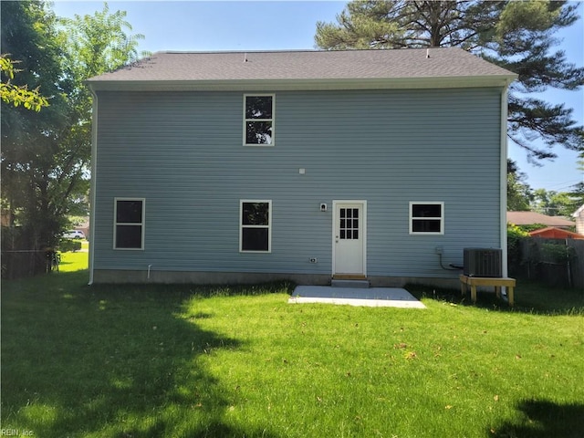 rear view of house featuring a patio, central AC, and a lawn