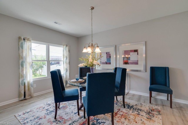 dining room with an inviting chandelier and wood-type flooring