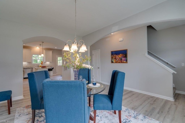 dining space featuring a notable chandelier and light wood-type flooring