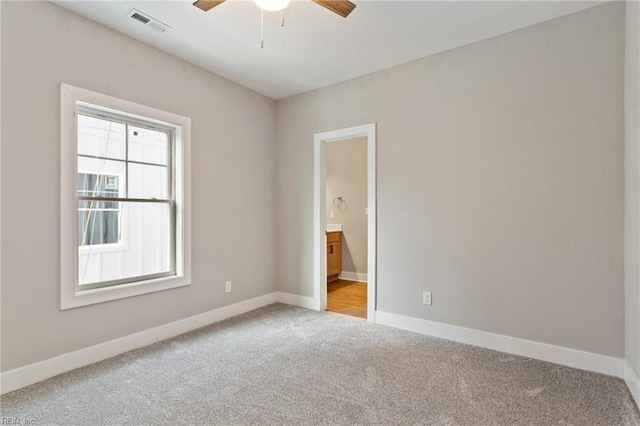 carpeted spare room featuring ceiling fan