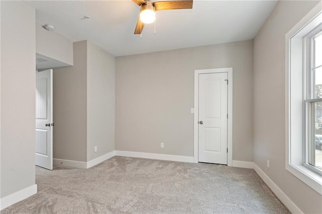 unfurnished room featuring ceiling fan and light carpet