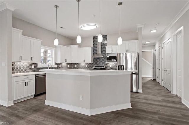 kitchen with a kitchen island, stainless steel appliances, decorative light fixtures, and white cabinetry