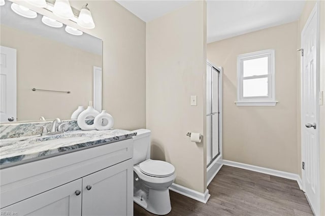 bathroom with vanity, toilet, wood-type flooring, and walk in shower