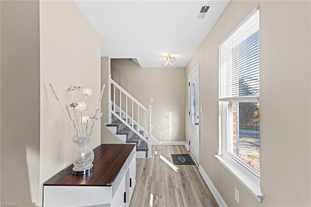 foyer entrance with plenty of natural light and light hardwood / wood-style flooring