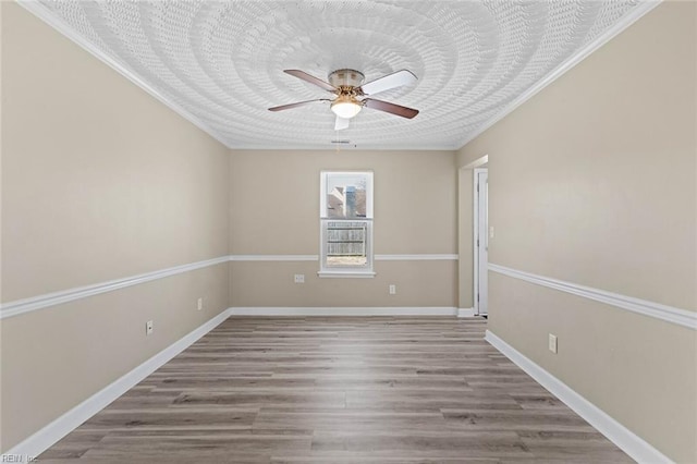 empty room featuring ceiling fan, ornamental molding, and hardwood / wood-style flooring