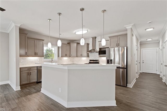 kitchen with stainless steel appliances, decorative light fixtures, a center island, wall chimney exhaust hood, and tasteful backsplash