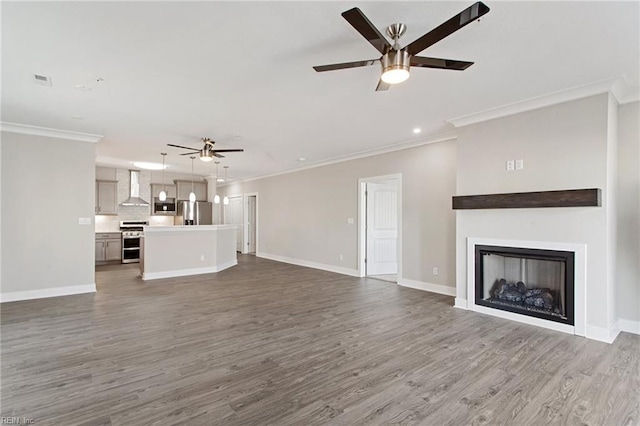 unfurnished living room with ceiling fan, crown molding, and hardwood / wood-style floors