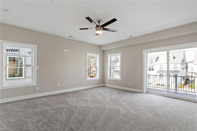 carpeted spare room featuring ceiling fan