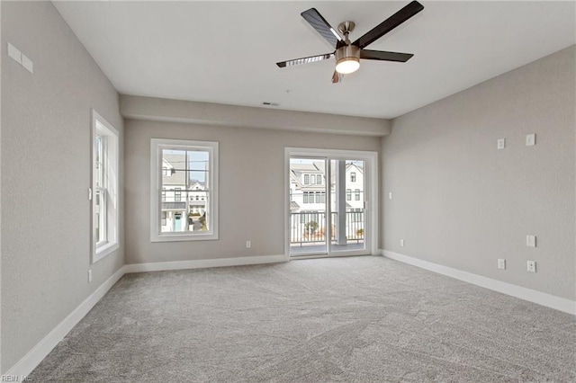 carpeted empty room with ceiling fan and a healthy amount of sunlight