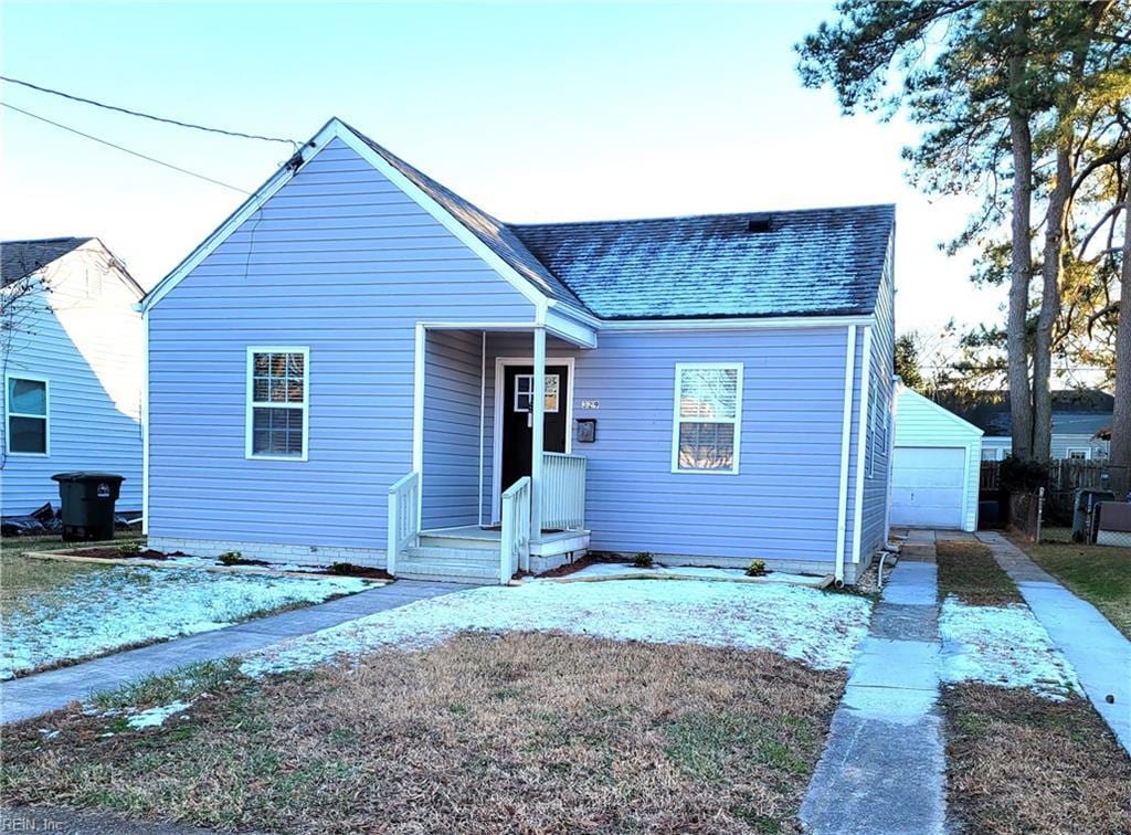 view of front of house with a garage and an outbuilding