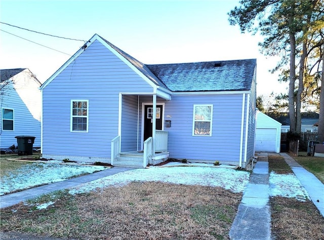 view of front of house with a garage and an outbuilding