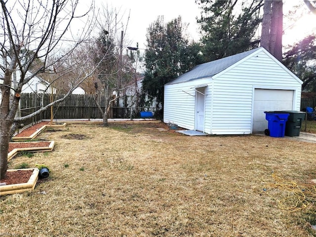 view of yard featuring a garage and an outbuilding