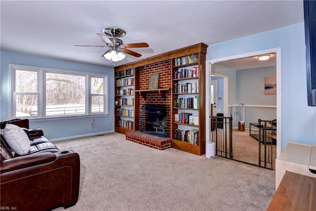 carpeted living room with ceiling fan, built in features, and a fireplace