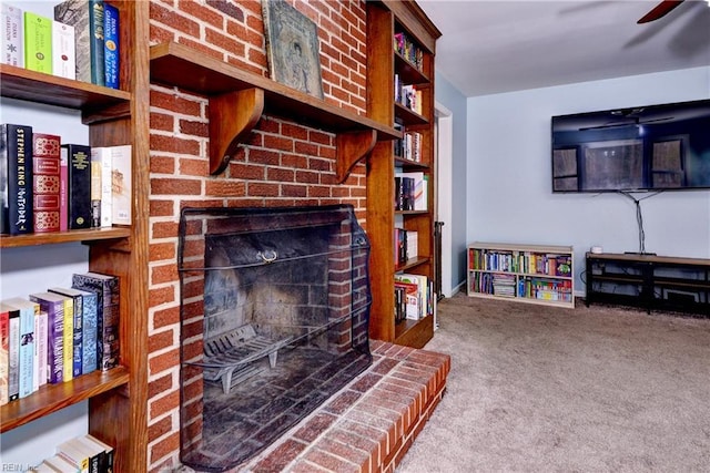 carpeted living room featuring ceiling fan and a fireplace