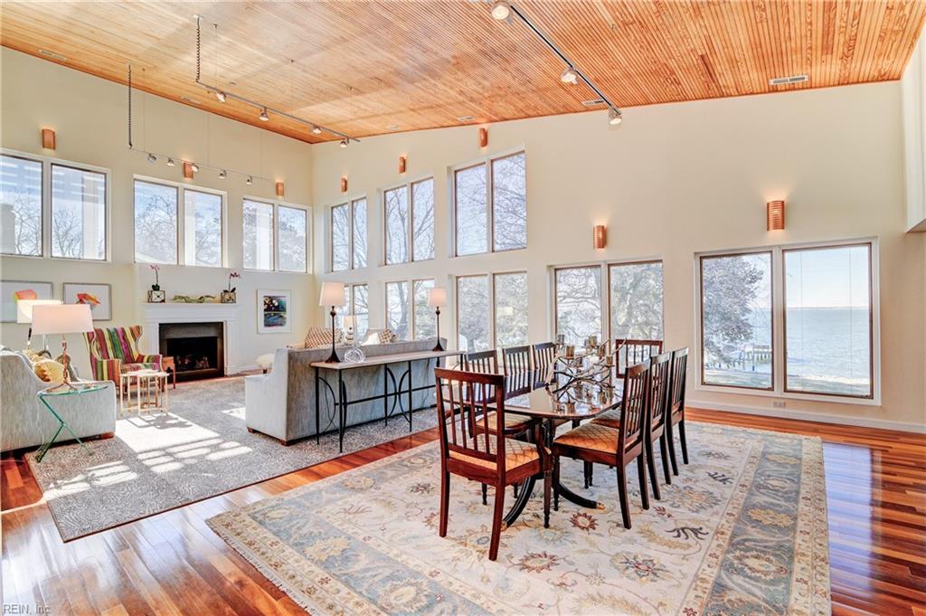 dining area featuring a towering ceiling, light wood-type flooring, rail lighting, and wood ceiling