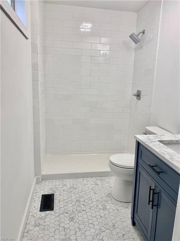 full bathroom with visible vents, baseboards, toilet, a stall shower, and vanity