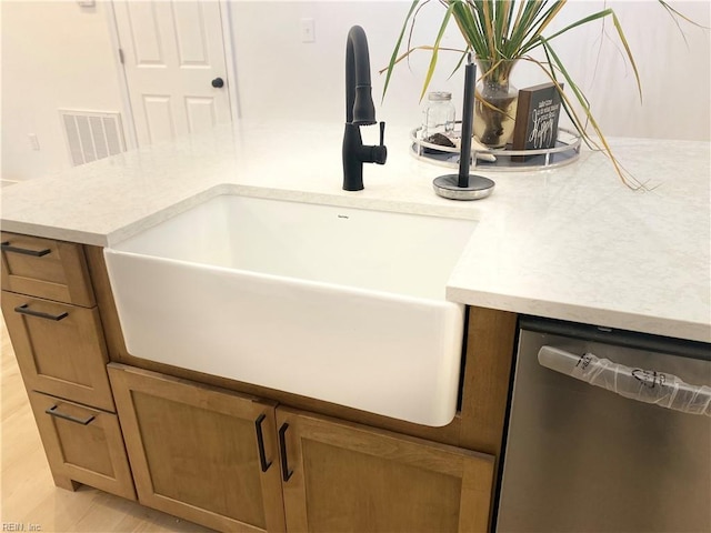 details featuring brown cabinetry, visible vents, dishwasher, and a sink