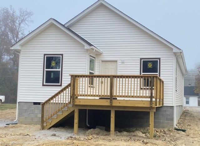 rear view of house featuring a wooden deck and stairs