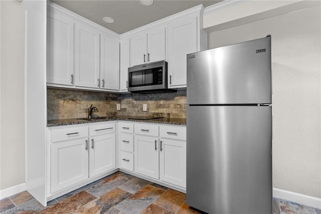 kitchen featuring white cabinets, dark stone countertops, and appliances with stainless steel finishes