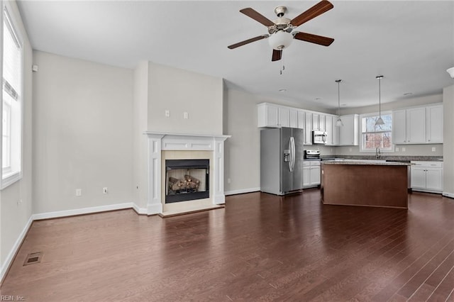 kitchen featuring pendant lighting, a center island, stainless steel appliances, dark hardwood / wood-style flooring, and white cabinets