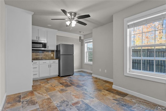 kitchen featuring white cabinets, ceiling fan, backsplash, and appliances with stainless steel finishes