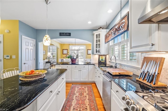 kitchen featuring sink, white cabinetry, dishwasher, hanging light fixtures, and extractor fan