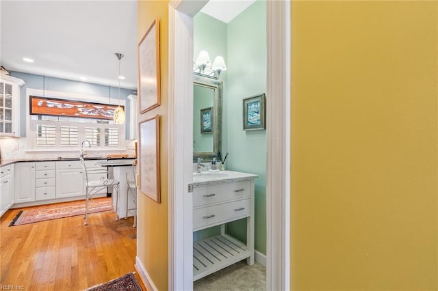 bathroom featuring wood-type flooring, vanity, and decorative backsplash