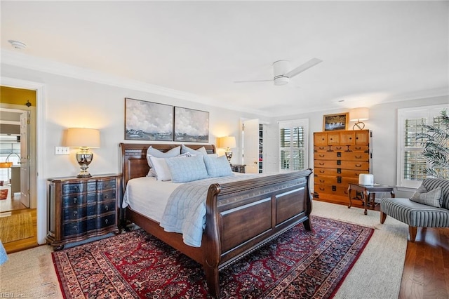 bedroom featuring ceiling fan, crown molding, and wood-type flooring