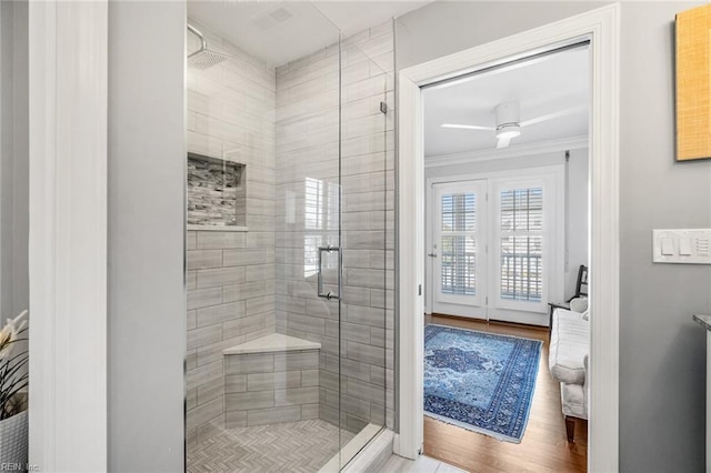 bathroom with an enclosed shower, hardwood / wood-style floors, and crown molding