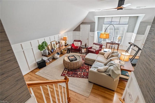 living room featuring ceiling fan, light wood-type flooring, and lofted ceiling